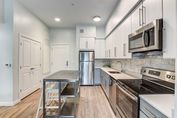 A kitchen with white cabinets and stainless steel appliances